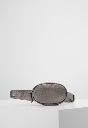 Petit sac banane ovale métallique gris avec fermeture éclair, exposé sur un piédestal blanc sur fond uni.