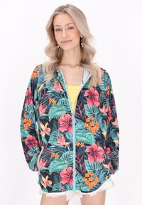 Jachetă ușoară cu fermoar, prezentând un imprimeu floral tropical vibrant în nuanțe de roz, portocaliu și verde, pe un fundal întunecat. Are manșete elastice.