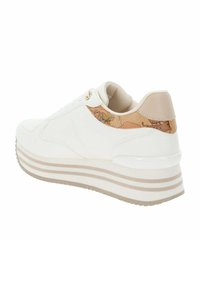 Sneaker bianco in pelle con accenti beige e un tallone a motivo mappa. Presenta una suola spessa a righe e occhielli decorativi dorati.