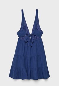 Marineblaues ärmelloses Kleid mit tiefem V-Ausschnitt, vorderer Schleifendetail und gestuftem Rüschensaum auf hellem, flachem grauem Hintergrund.