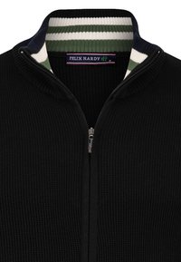 Sort strikket zip-sweater med en ribbet krave, der har grønne og hvide striber. Indeholder et mærke inde i kraven.
