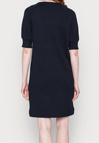 Navy blue mekko lyhythihaisilla, rentoa mallia, jossa on pyöreä pääntie ja hillityt puffihihat. Sujuva kangas ja polvimittainen helma.