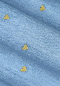 Lichtblauwe stof met een zachte textuur, voorzien van verspreide kleine, goudkleurige geborduurde hartjes in een eenvoudig patroon.