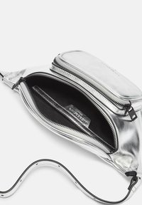 Srebrna metaliczna torebka crossbody o teksturowanej powierzchni, z zamykaną komorą i gładkim, regulowanym paskiem. Wnętrze to czarna tkanina.