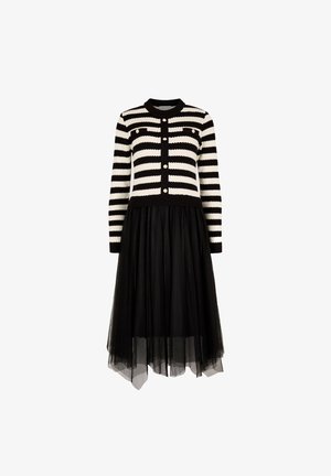 Sort og hvid stribet kjole med ribbet bodice, knaplukning og lange ærmer; lagdelt tulleskørt tilføjer volumen og tekstur.
