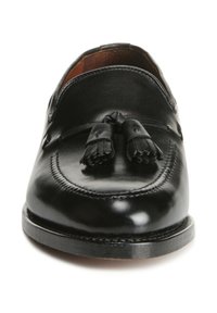 Schwarze Lederloafers mit Quastenakzenten, glatter Oberfläche, abgerundetem Zehenbereich und genähten Details entlang der Kante des Schuhs.