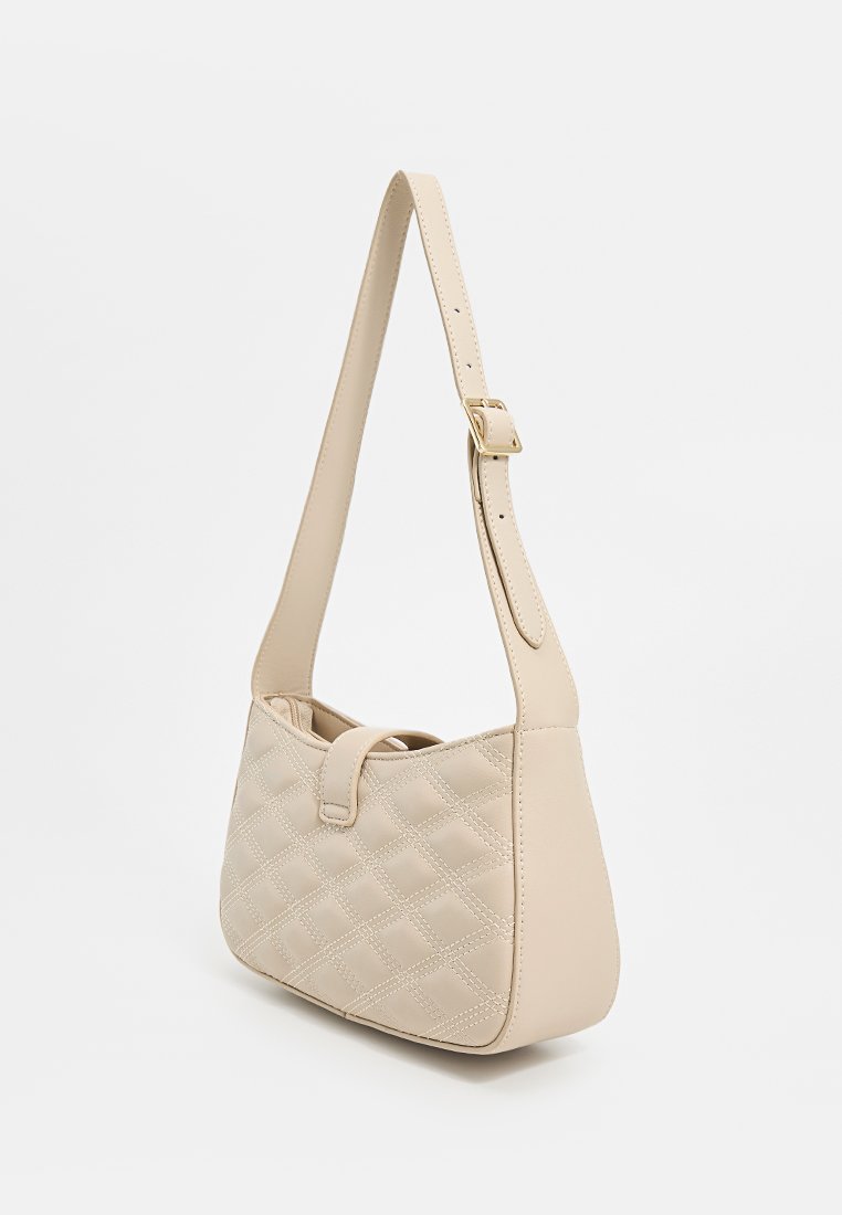 Beige gesteppte Handtasche mit strukturiertem Finish, einem einstellbaren Tragegurt und Druckknopfverschluss. Besitzt eine glatte, abgerundete Form.