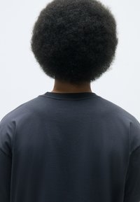 Mørkeblå sweatshirt med rund hals, vist fra bagsiden. Har en blød bomuldsstruktur og en afslappet pasform. Korte ærmer, minimal detaljer.