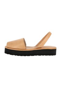 Sandales slingback en cuir tan avec un bout rond, semelle plate en caoutchouc noir et design minimaliste, présentant une texture lisse.