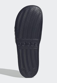 Black rubber outsole with herringbone pattern, featuring embossed "adidas" logo and a smooth finish for traction.