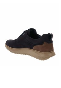 Zapatilla de cuero azul marino con suela de goma beige, con forma redondeada, cierre de cordones y detalle en ante marrón contrastante en el talón.