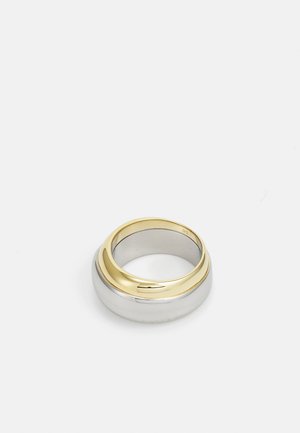 Anillo bicolor que presenta una banda de plata lisa con una parte superior chapada en oro, diseño redondeado con una superficie brillante y un sutil grabado.