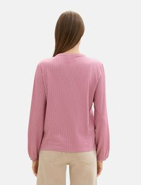 Langärmliges Oberteil in rosa und weißen vertikalen Streifen, aus weichem Stoff gefertigt, mit Rundhalsausschnitt und sanft gepufften Ärmeln.