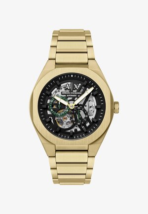 Zlatý náramkový hodinky Armani Exchange s odhaleným černým a stříbrným automatickým strojkem, subciferníky se zelenými akcenty a kovovým náramkem.