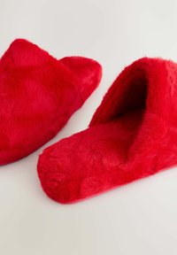 Røde faux fur hjemmesko med en blød, struktureret overflade og åben bagdel. Har runde tæer og en fyldig foring for komfort.