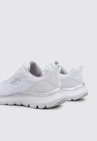 Scarpe sportive bianche con tessuto in rete e accenti sintetici, caratterizzate da una suola ammortizzata, un design flessibile e un dettaglio con logo sul lato.