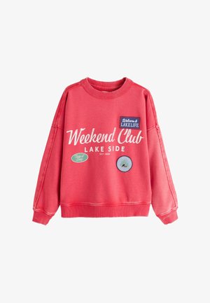 Red sweatshirt with "Weekend Club Lake Side" text and three patches reading "Welcome to Lakelife," "Take it Easy," and a camping scene badge.