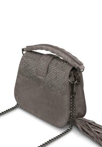 Borsa in suede grigia con una parte superiore borchiata, manico intrecciato, tracolla in catena argentata e un pon pon decorativo sul lato.