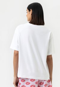 Witte katoenen t-shirt met korte mouwen en een relaxte pasvorm, met een ronde hals en een gladde textuur, weergegeven vanuit de achterkant.