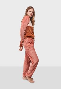 Flanell-Loungewear-Set in einem Farbverlauf aus Rosa und Rost; langärmliges Oberteil mit einem Farbkombinationsdesign, passende Jogginghose.