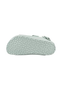 Ljusgrön sandalsole med ett texturerat vågmönster, med två justerbara remmar och en robust gummibyggnad.