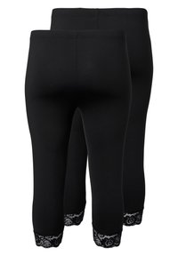 Mustat leggingit, joissa on tiukka malli ja joissa on pitsireuna helmassa. Valmistettu pehmeästä kankaasta, joka näyttää sileältä.