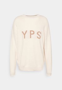 Pull crème à coupe décontractée, arborant un logo "YPS" beige contrastant sur la poitrine, avec une texture tricotée douce et des poignets côtelés.