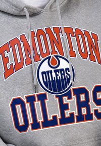 Grauer Kapuzenpullover mit "EDMONTON" in fetten orangen und weißen Buchstaben, mit "OILERS" in marineblau. Enthält ein rundes Teamlogo auf der Vorderseite.