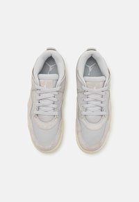 Chaussures de sport grises en suède et mesh, avec des lacets ronds, un col rembourré, et un logo sur la languette et la semelle intérieure.