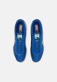 Zapatillas deportivas azules con un diseño de ante y malla, punta redonda, acentos en franjas blancas y suela de goma marrón. Se incluyen los cordones.