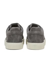 Graue Wildledersneaker mit strukturierten Oberflächen, weißer Gummisohle und einem Zugtab hinten. Mit geprägtem Markenlogo an der Ferse.