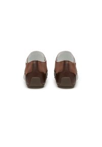 Un paio di scarpe casual in pelle e suede marrone viste da dietro su uno sfondo bianco con impugnature in gomma sul tacco.