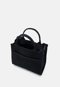 Czarna prostokątna torba materiałowa z dwoma uchwytami, przednią kieszenią i zamknięciem na suwak u góry, zaprezentowana na białym tle.