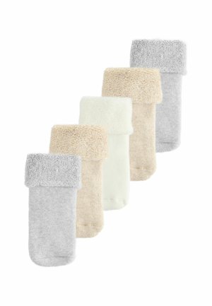 Cinq paires de chaussettes confortables et repliées dans des teintes de gris, beige et blanc cassé, disposées en diagonale sur un fond blanc.