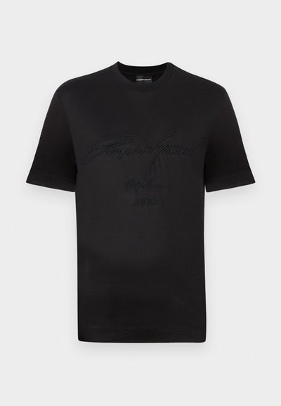Μαύρο βαμβακερό t-shirt με στρογγυλή λαιμόκοψη, κοντά μανίκια και ανάγλυφο σχέδιο κειμένου "Emporio Armani Milan 1981" στο μπροστινό μέρος.