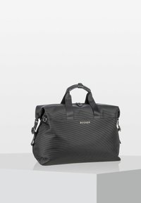 Sort nylon rejsetaske med dobbel toppløkker, justerbar skulderrem, struktureret overflade og et frontlogo. Ensartet design, rummelig form.