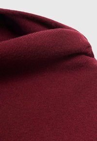 Burgundowa dzianina swetra z fakturą prążkowaną, z miękkim, złożonym dekoltem i gładkim wykończeniem dla dopasowanego kroju.