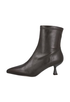 Botín negro de cuero con punta afilada y tacón corto y delgado sobre fondo blanco.