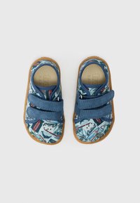 Buty na rzepy z niebieską cholewką z tkaniny, ozdobioną kolorowym nadrukiem graficznym przedstawiającym łodzie i wzory. Podeszwy gumowe; lekkie i elastyczne.