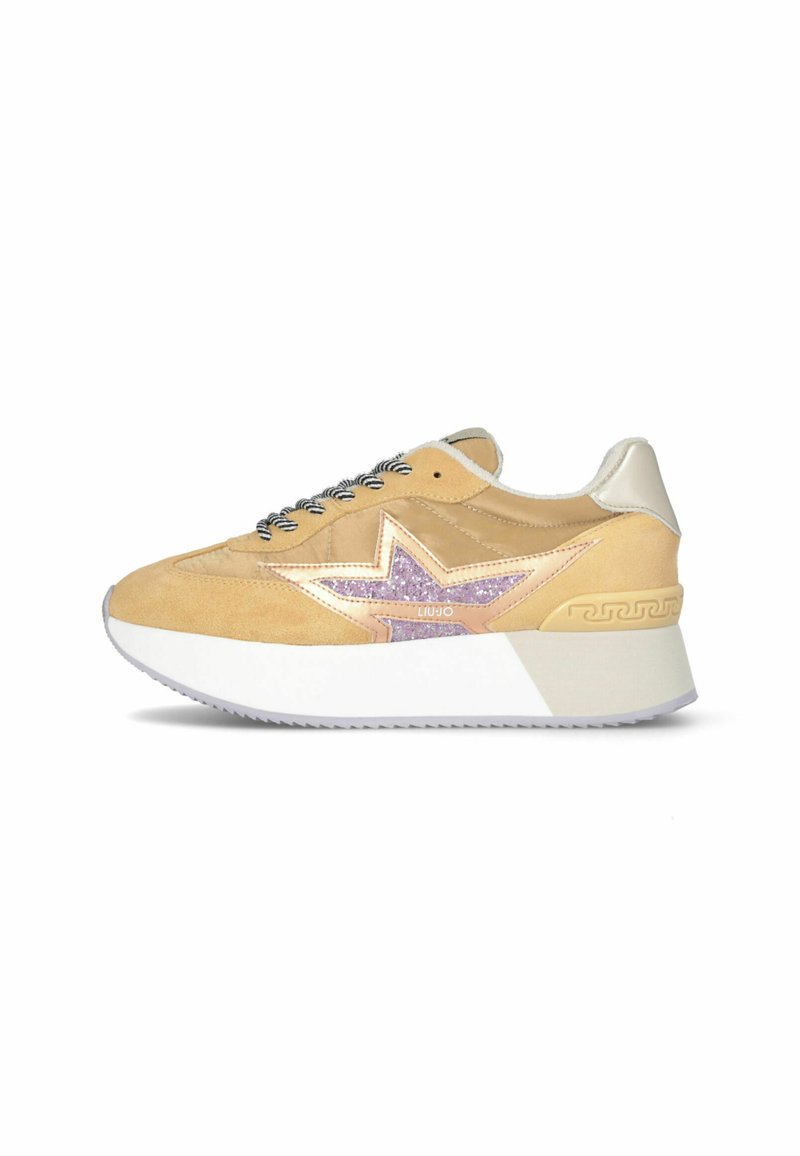 Zapatilla beige con suela blanca, cordones en blanco y negro, y detalle de estrella de purpurina rosa en el lateral, mostrada en vista de perfil.