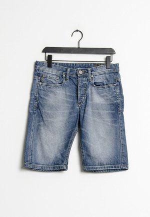 Vaaleansiniset farkkushortsit, joissa viisi taskua, etupuolen nappi- ja vetoketjukiinnitys sekä rispaantuneet lahkeensuut. Rippuvat mustassa muovihangassa.