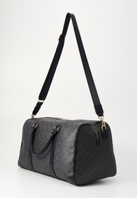 Μαύρη τσάντα σχεδιαστή με υφή από συνθετικό υλικό, χρυσό φερμουάρ, διπλές λαβές και ρυθμιζόμενο ιμάντα ώμου. Διαθέτει διακριτό σχέδιο με λογότυπα.
