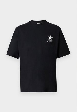 Fekete rövid ujjú póló egy kis fehér csillaggal és "gl*w" feliratú logóval a bal mellkason, egyszínű fehér háttéren bemutatva.