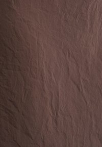 Tissu marron avec des plis et des froissements visibles créant une texture irrégulière sur toute la surface.