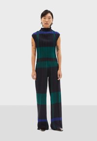 Mono de tirantes acanalado en un oscuro color navy con rayas verticales en verde esmeralda y azul vibrante; el diseño de pierna ancha realza el movimiento.