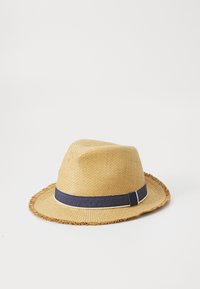 Sombrero de paja tipo fedora con un ala ancha y deshilachada, que presenta una banda azul marino con una franja blanca. El material es tejido, lo que proporciona una apariencia texturizada.
