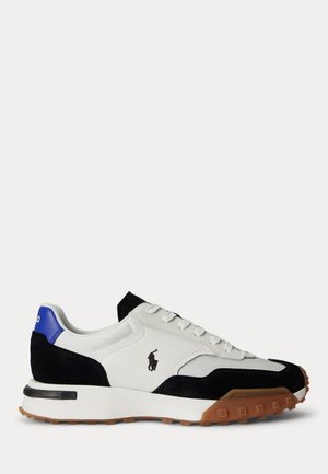 Baskets blanches avec détails en daim noir, accent bleu au talon, semelle texturée marron et logo joueur de polo noir sur le côté.