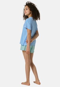 Striped blue and white cotton t-shirt paired with mint green shorts. Short sleeves and a relaxed fit, with a round neckline.