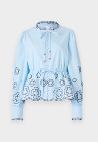 Blusa azzurro chiaro con maniche lunghe, scollatura arricciata e cordoncino. Presenta motivi floreali decorativi e chiusura con bottoni nella parte anteriore.