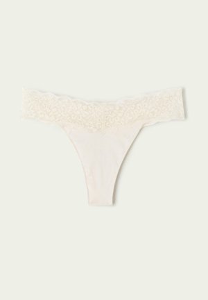 Lace-trimmed thong in light cream with a soft, smooth fabric body. The lace waistband features a floral pattern for added detail.
